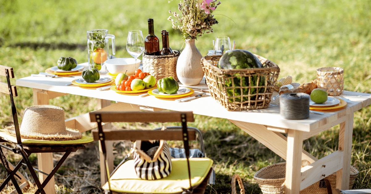 wooden table in garden featuring fruits and drinks for picnic