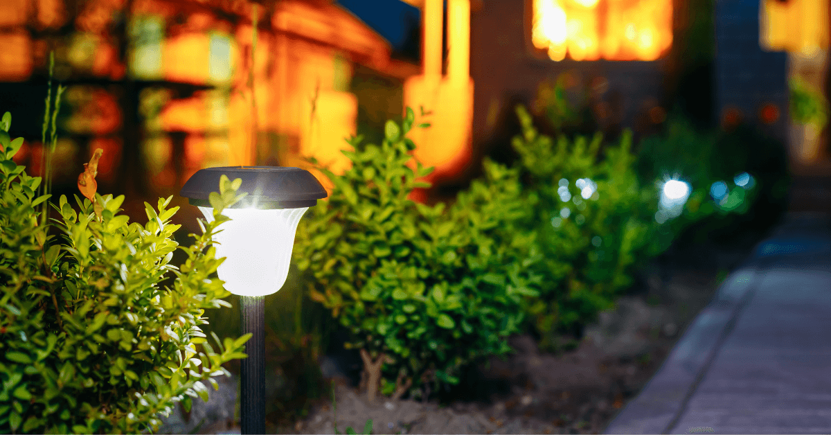 garden solar stake light in ground beside green foliage beside walkway
