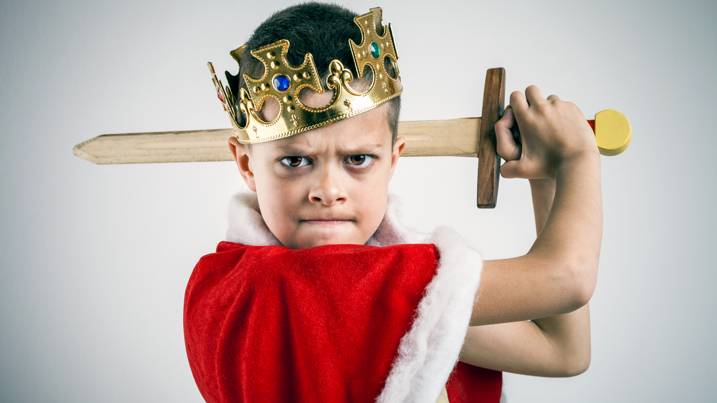 little boy dressed as a king with gold crown and outfit