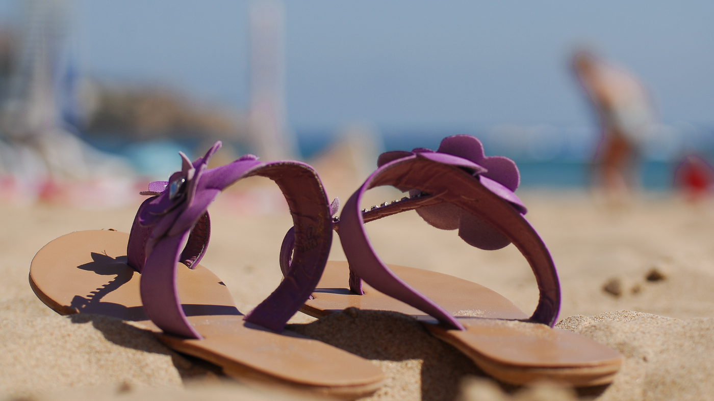 summer sandals with purple finish on beach