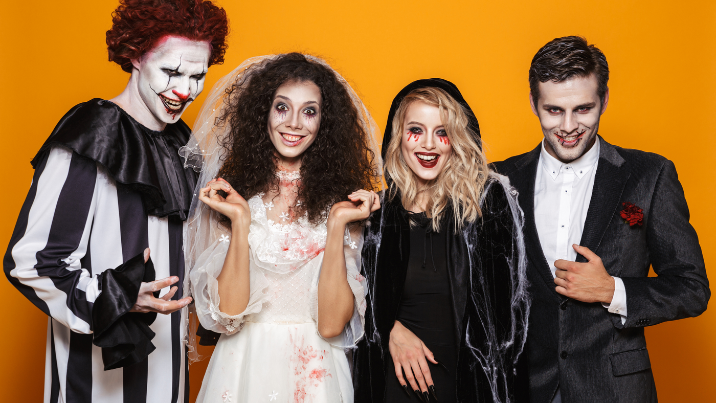 group of friends dresses as scary halloween characters including killer clown, vampires and bloody bride