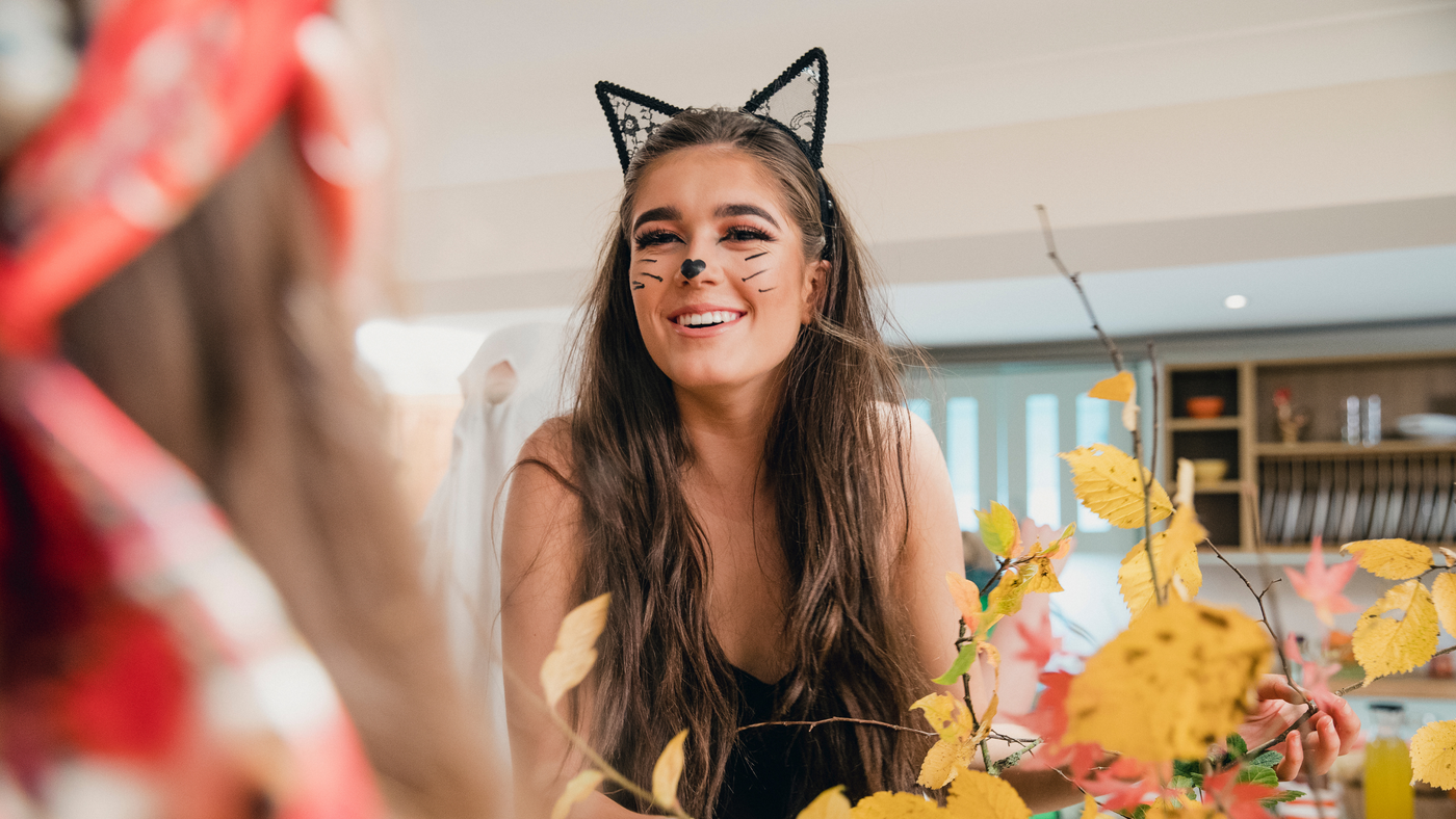 lady wearing a lace pair of cat ears and talking to a friend in the living room