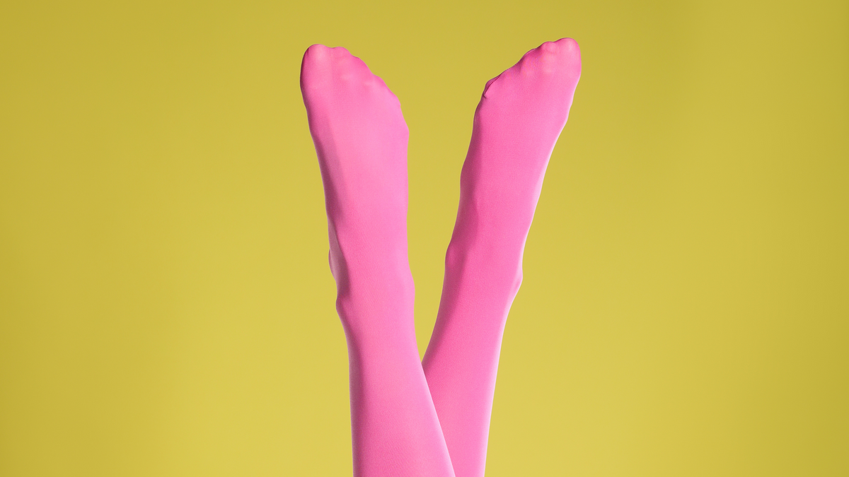 person wearing bold pink tights against a yellow background