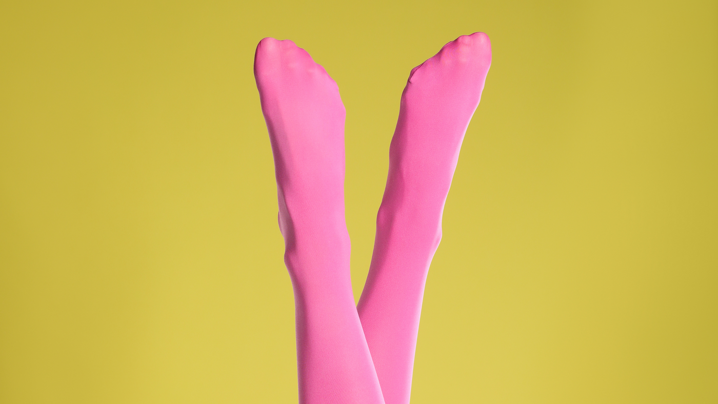 person wearing bold pink tights against a yellow background