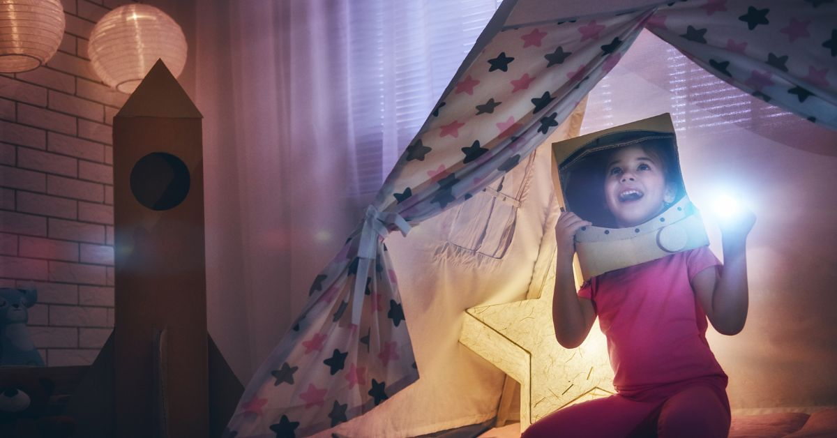 little girl in tent with cardboard space rocket for world book day 2024