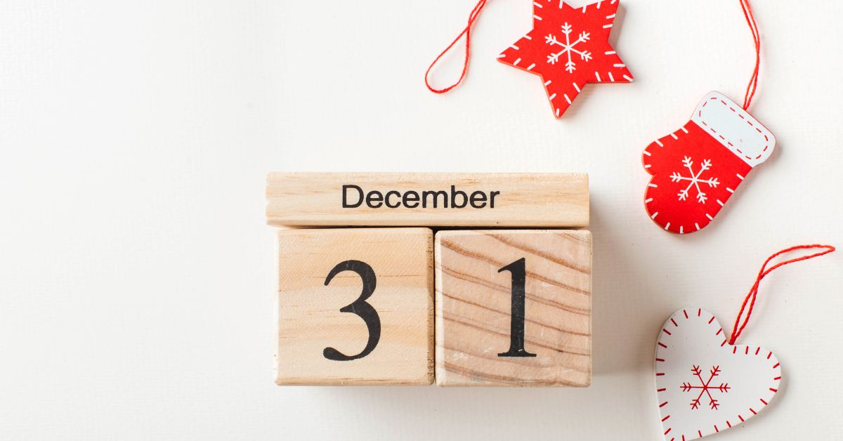wooden advent calendar blocks showing december 21st date beside red christmas decorations