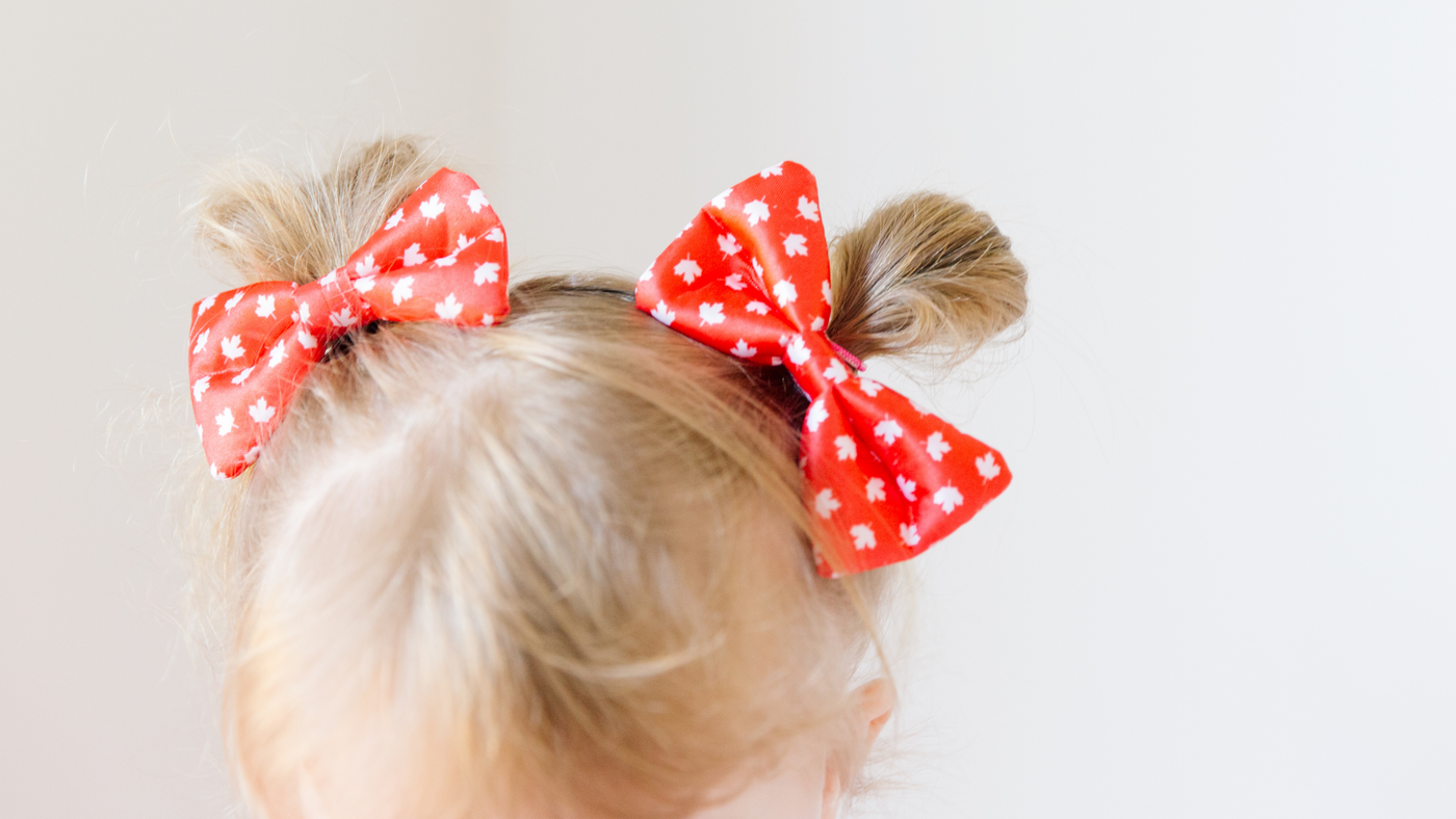 little girls hair in double buns finished with red and white hair bows