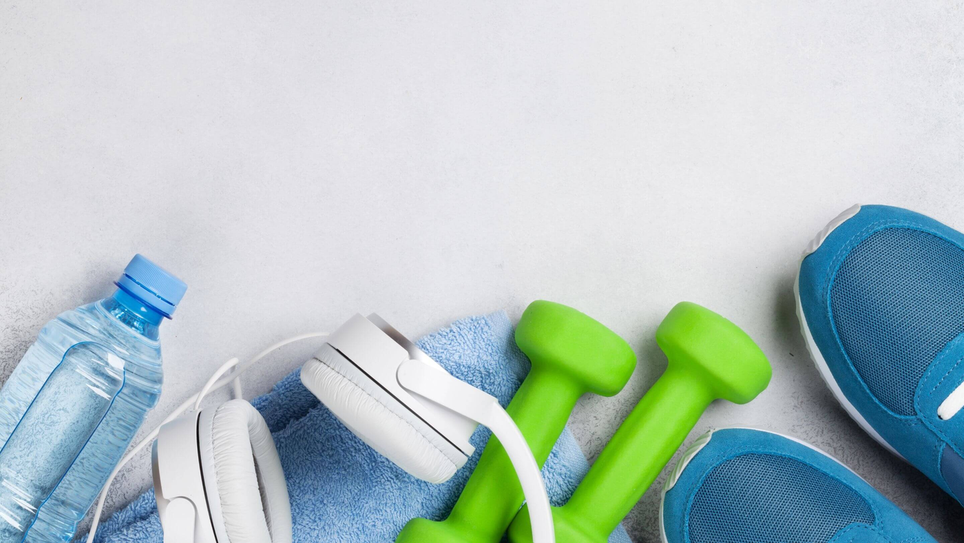 water bottle, headphones, towel and training shoes on white background