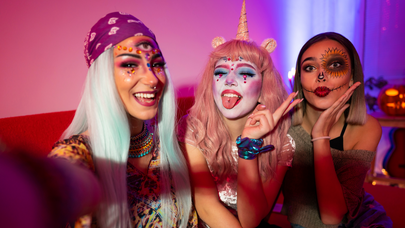 three teenage girls dressed up as a unicorn, a pumpkin and a fortune teller