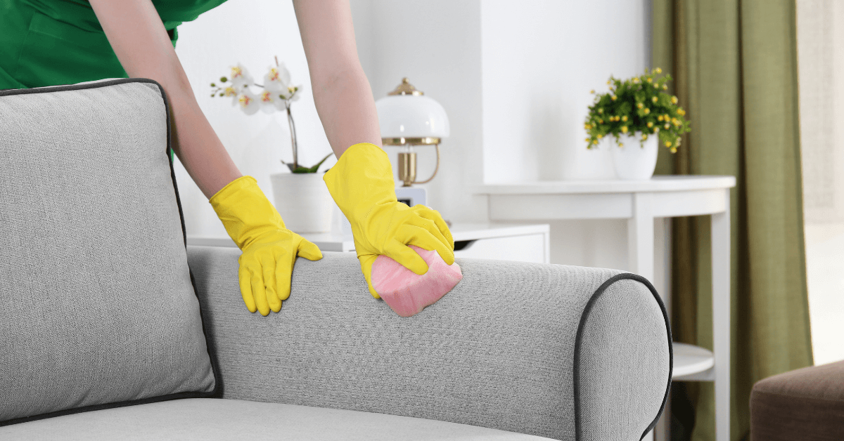 person wearing cleaning gloves wiping worktop counter with blue microfibre cleaning cloth
