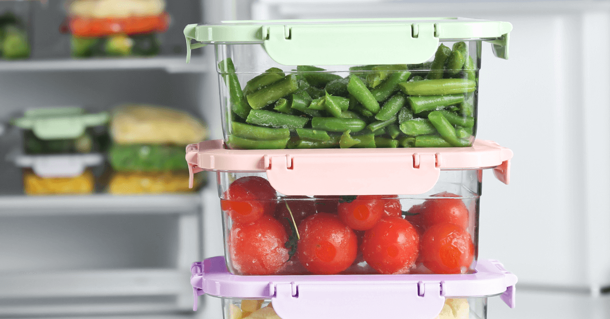 person taking food containers filled with vegetables out of the fridge