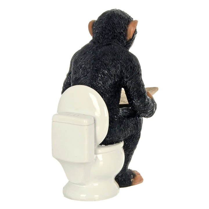 Back view of a Cheeky Monkey reading a newspaper while sitting on the toilet
