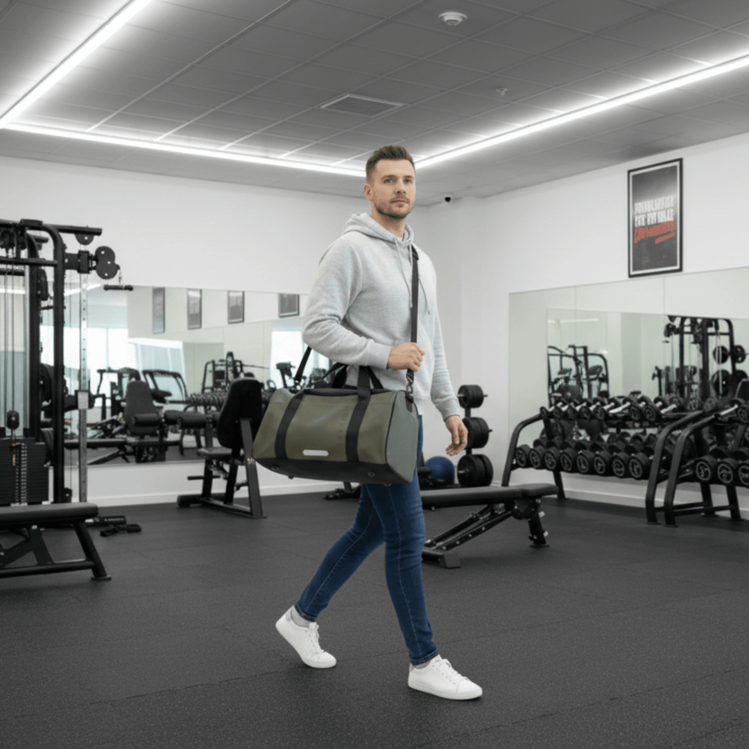 Man walking through Gym to Changing room with Hodge and hodge Holdall in Safari green.