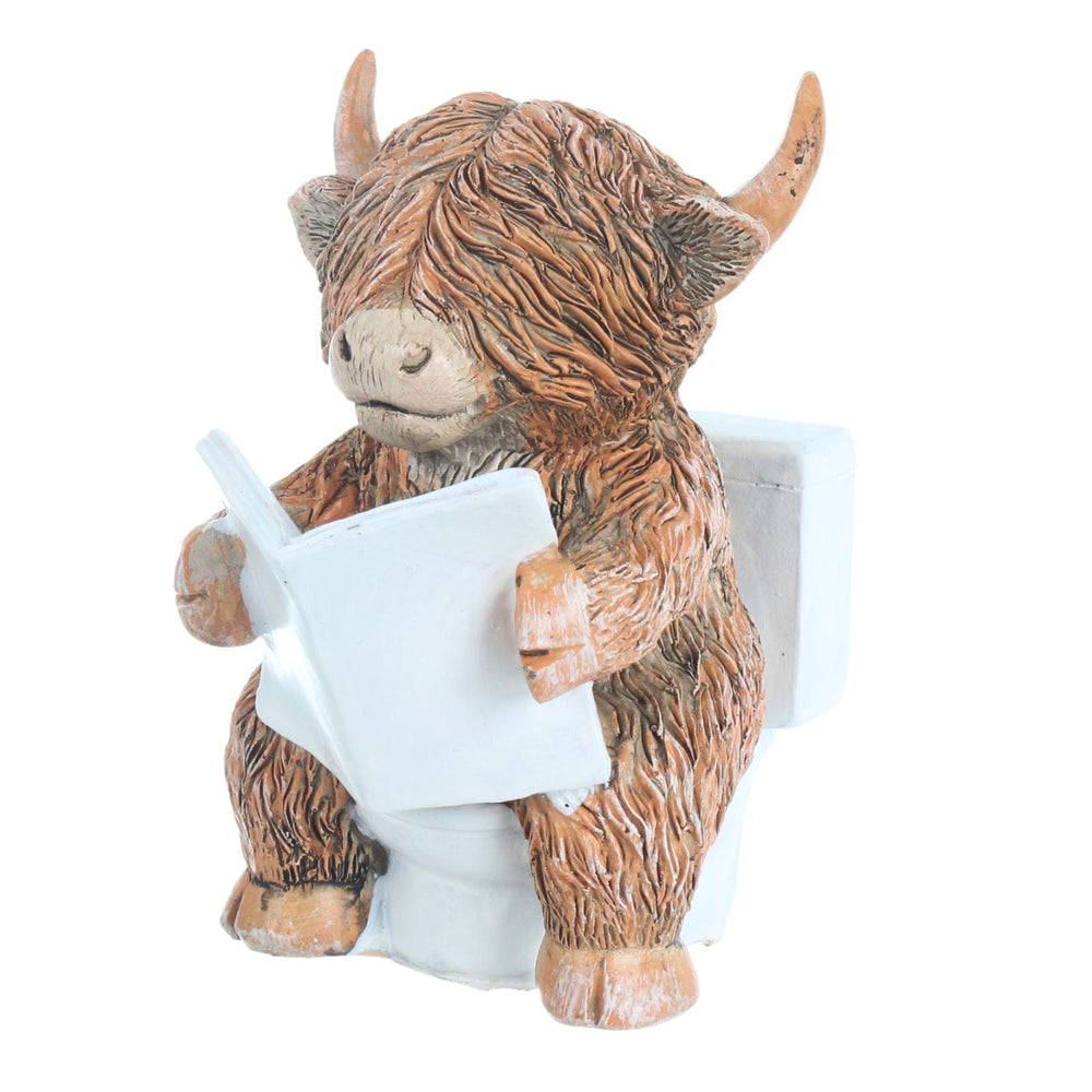 side view of highland cow on toilet reading the morning newspaper