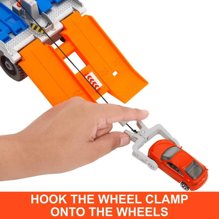 Hand hooking tow rope on a toy car
