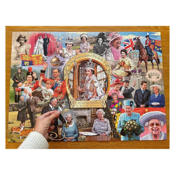 Hand with the last piece of a Queen Elizabeth II jigsaw puzzle