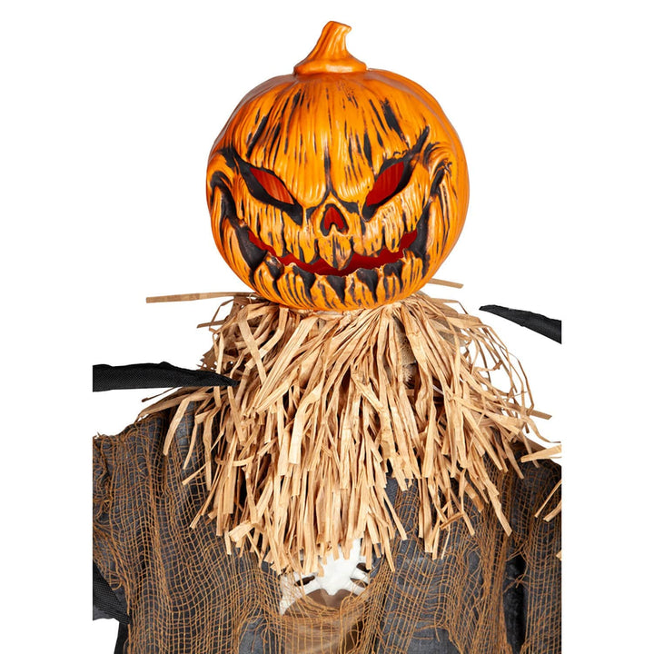 Close up of evil pumpkin scarecrow head with straw stuffing