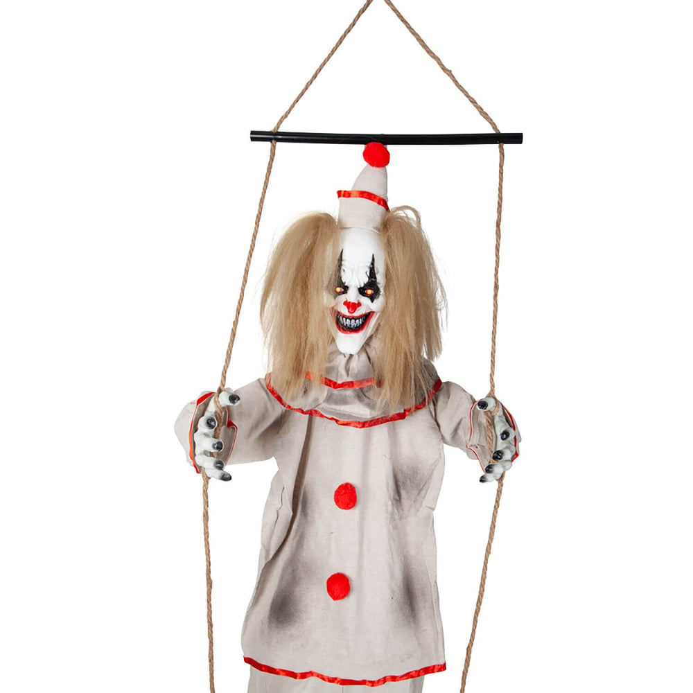 Close up of a scary clown on a swing with red eyes and evil grin