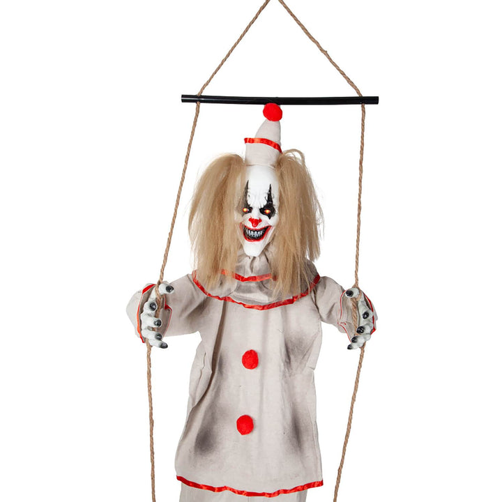 Close up of a scary clown on a swing with red eyes and evil grin