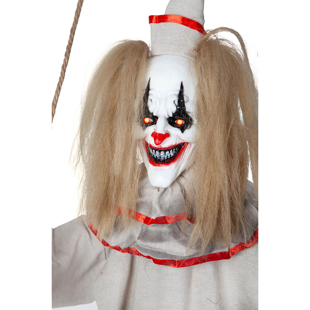 Close up of the face of a freaky clown with red eyes evil grin and messy hair