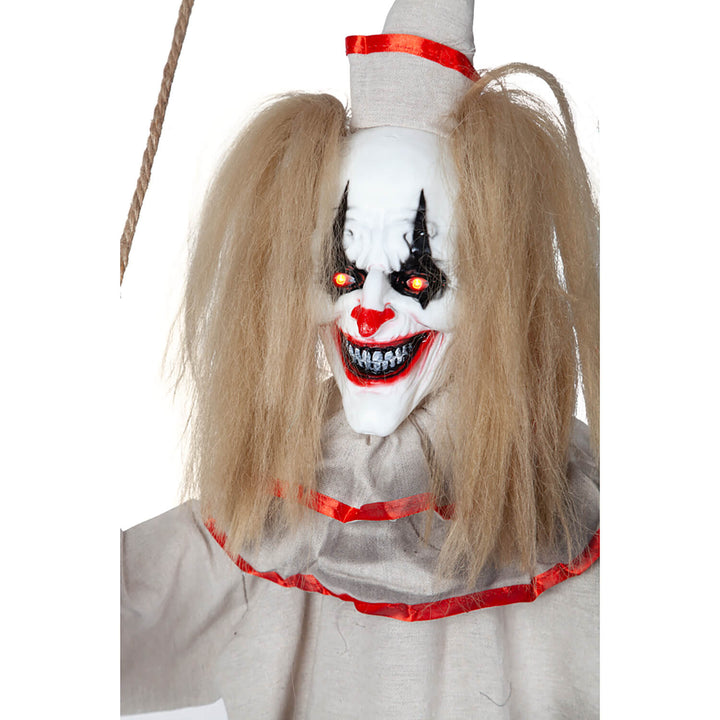 Close up of the face of a freaky clown with red eyes evil grin and messy hair