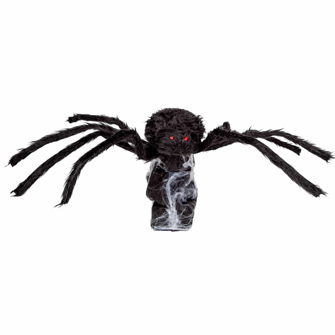 Large black hairy spider with red eyes on a cobweb rock decoration