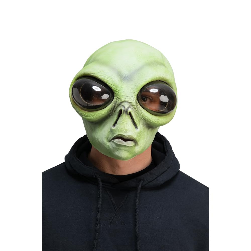 Person wearing a green alien mask with big bug eyes on a white background