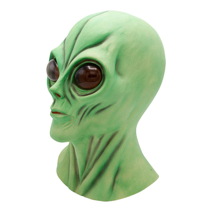 Side view of a green alien mask with large brown eyes on a white background