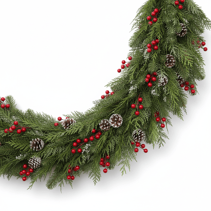 Christmas garland with green foliage, red berries, and pinecones on a white background