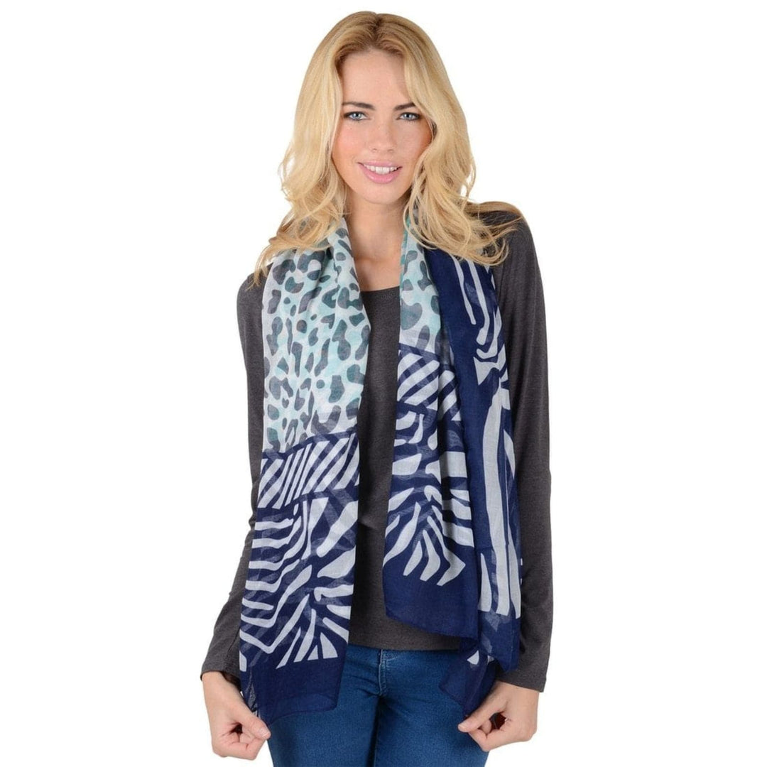 Woman wearing a patterned animal print scarf in navy blue and teal 
 on a white background
