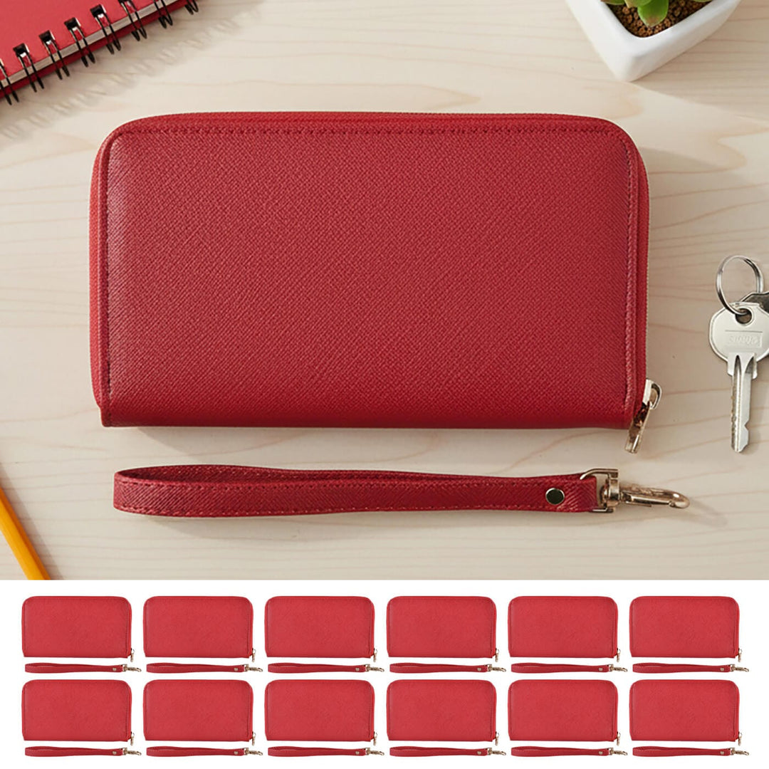 Red purse with wrist strap on a wooden surface with keys and a notebook.