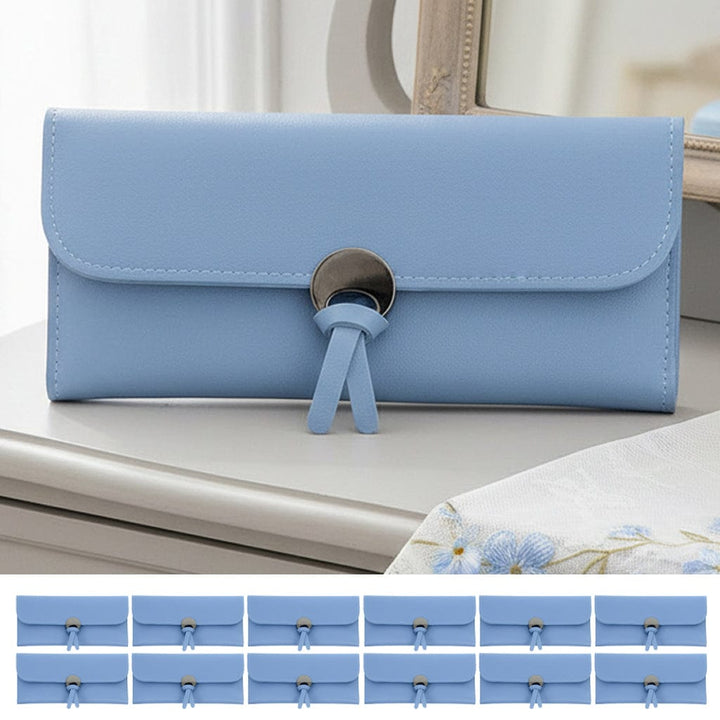 Blue clutch purse with a decorative fastener on a dressing table with 12 more small purses