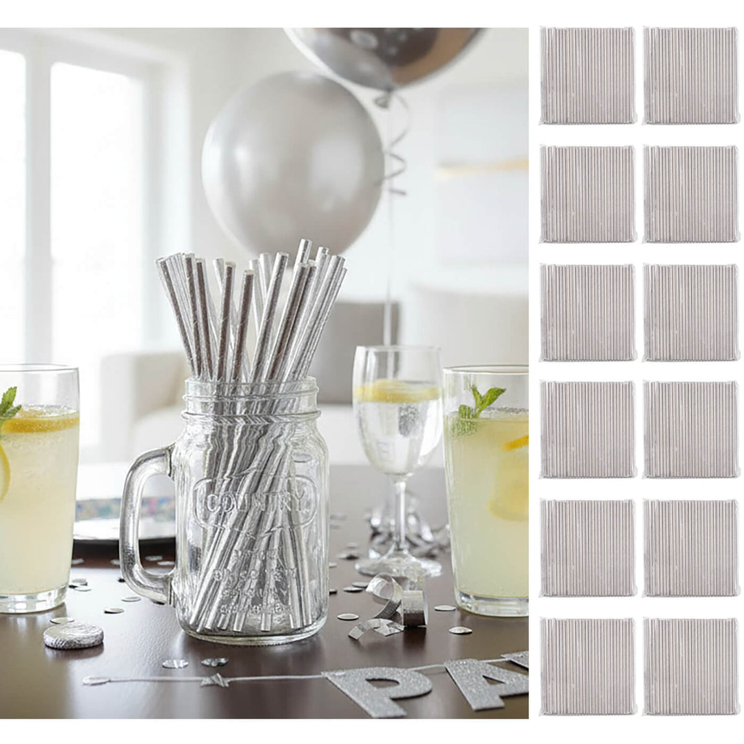 Silver paper straws in a jar with glasses of lemonade on a table, surrounded by silver party decorations.
