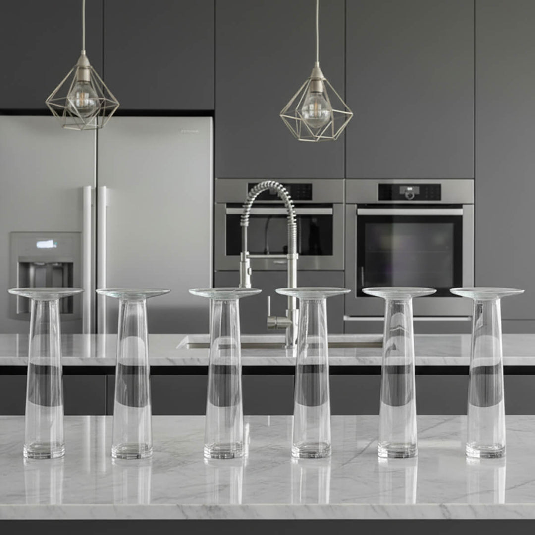 6 clear glass flower vases on a modern kitchen worktop