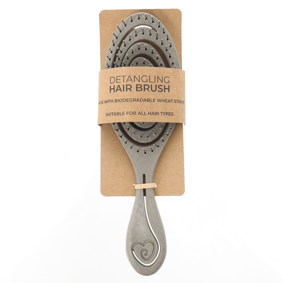 Detangling grey hairbrush with biodegradable wheat straw on a cardboard backing