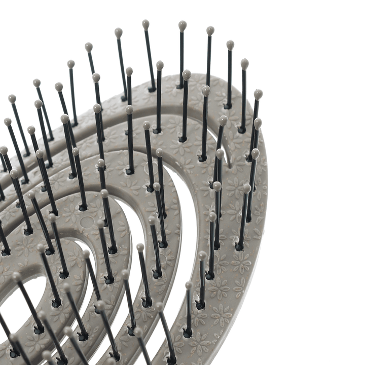 Close-up of a grey hairbrush with bristles on a white background