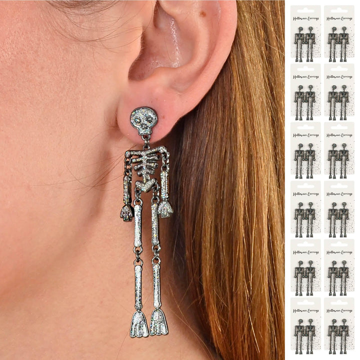 Long silver skeleton earring worn by a person with a side view of an ear and 12 pairs of earrings down the side