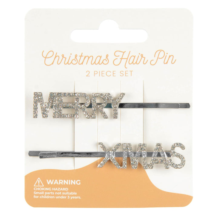 Two Christmas-themed hair pins on a packaging with &