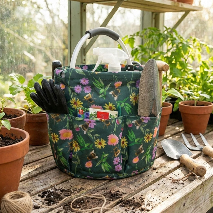 Gardening caddy with tools and gloves on a wooden table in a greenhouse setting