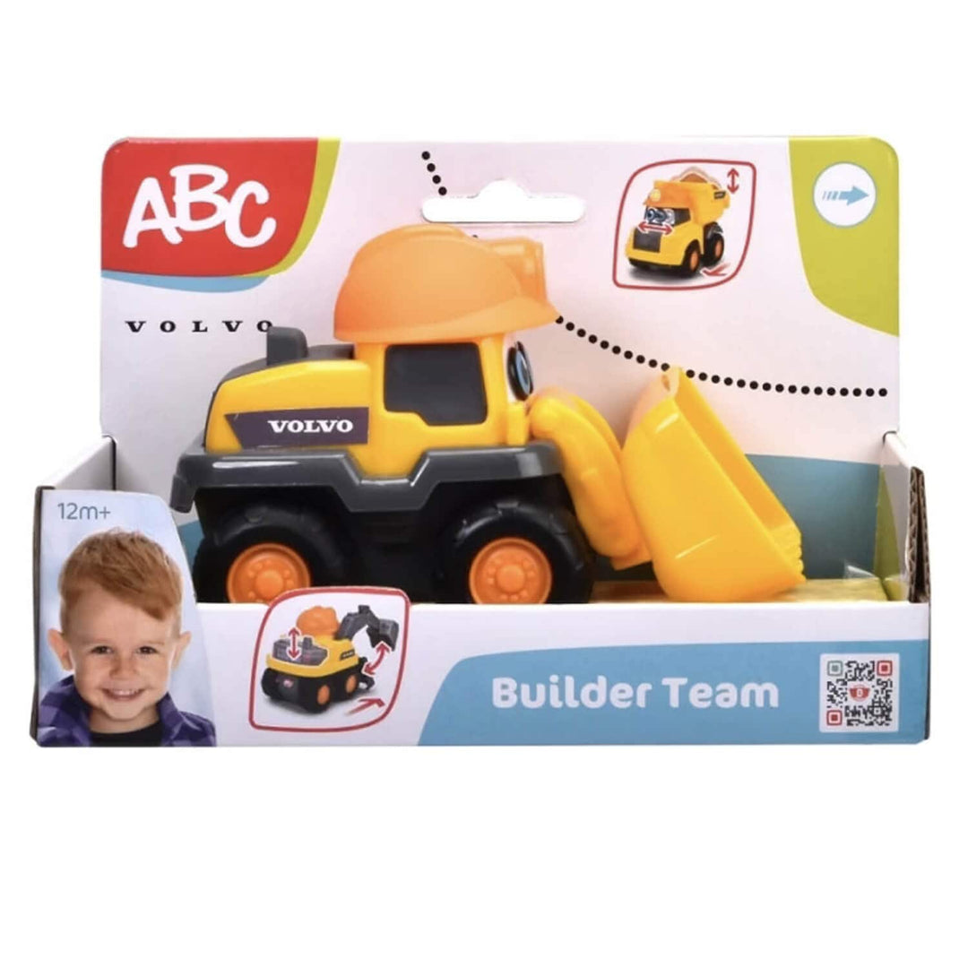 A yellow and black Volvo toy construction vehicle in its retail packaging, featuring a scoop attachment, with branding and age information visible on the box.