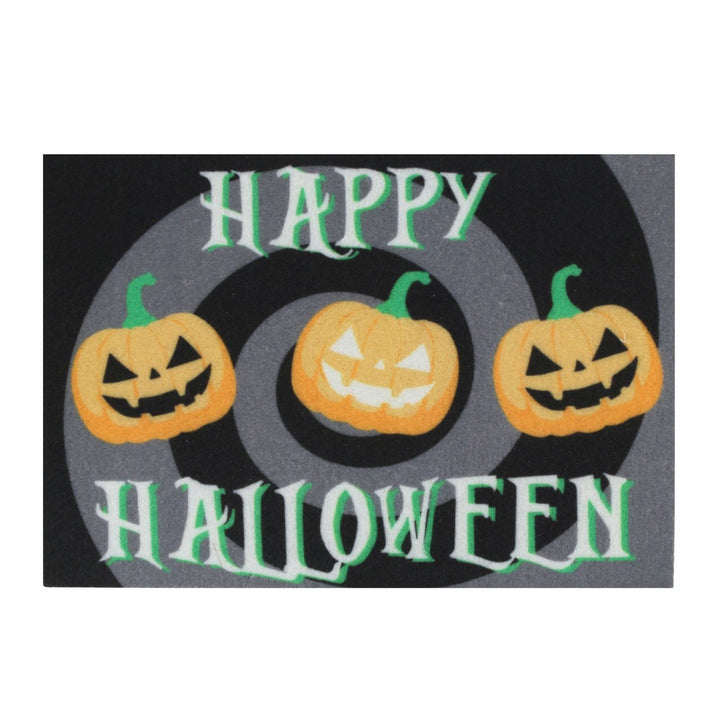 A rectangular Halloween-themed mat or sign with the words “HAPPY HALLOWEEN” in white and green lettering, featuring three orange jack-o'-lantern pumpkins on a dark gray spiral background.
