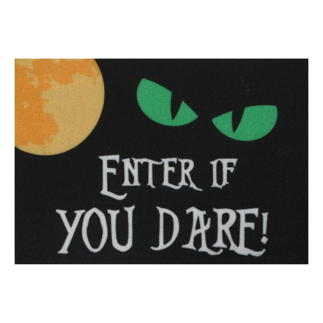 A rectangular black novelty door mat with a large orange moon on the left, green monster eyes at the top right, and the phrase "ENTER IF YOU DARE!" in stylised white lettering.