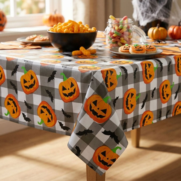 A Halloween-themed tablecloth with a gray and white buffalo check pattern, decorated with orange jack-o&