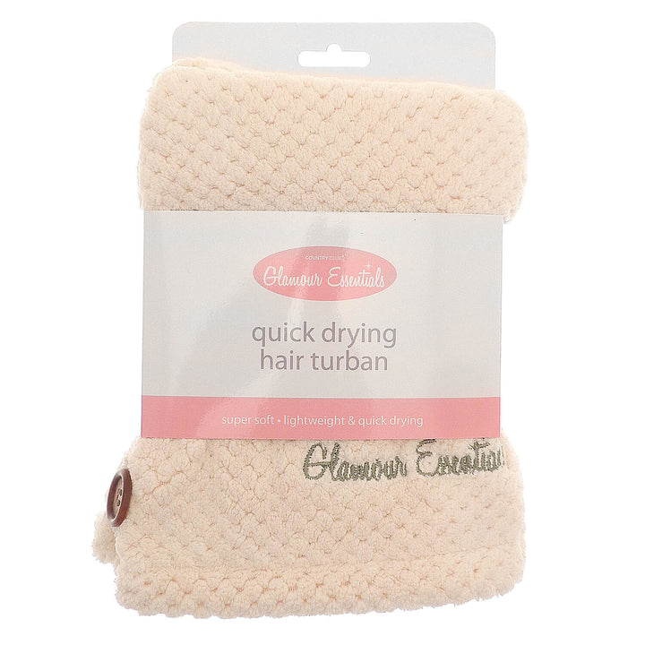 Cream colour quick drying hair turbie with packaging sleeve and hanger on a white background