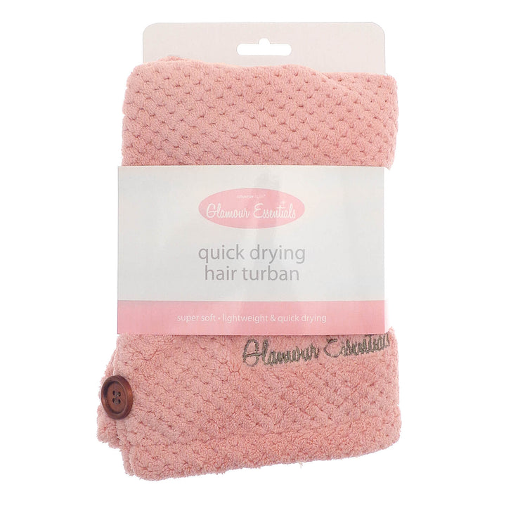Pink colour quick drying hair turbie with packaging sleeve and hanger on a white background