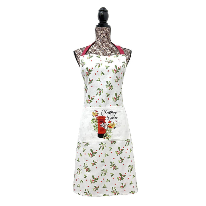A white apron on a mannequin features a front pocket with a red post box illustration and the text 'Christmas Wishes'.