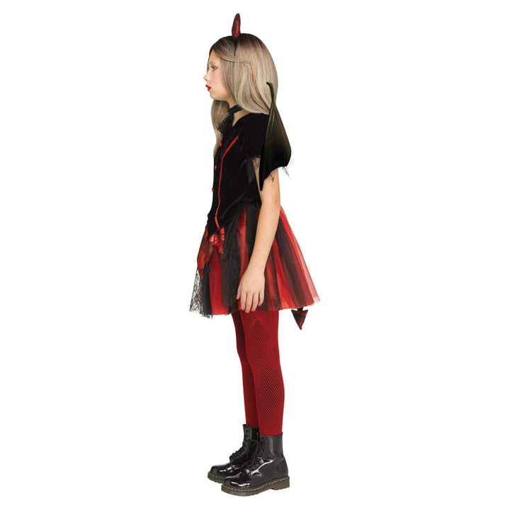 A child model shown in profile wearing a vampire costume, featuring a black top with red trim, a red and black tulle skirt, red fishnet tights, and black boots, set against a plain white background.