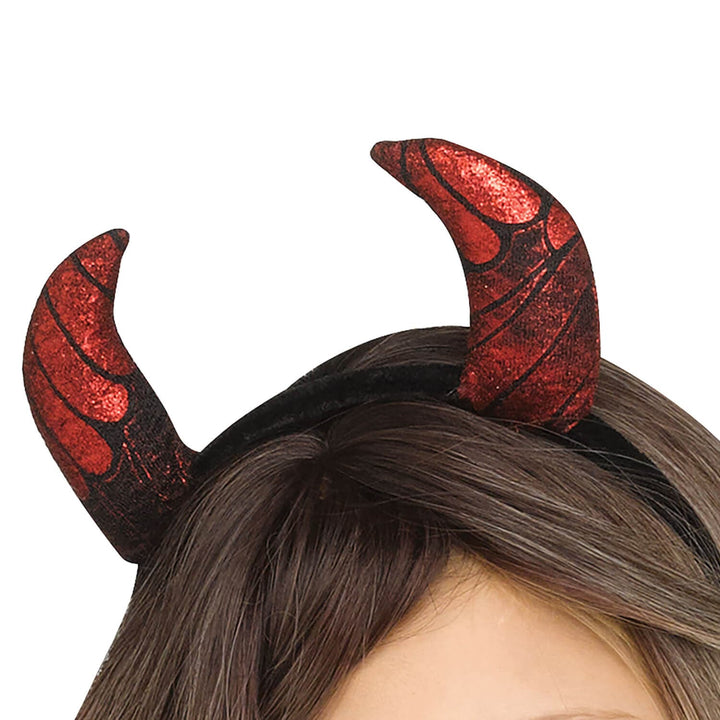 Red glitter devil horns with black textured detailing, shown worn on a person&