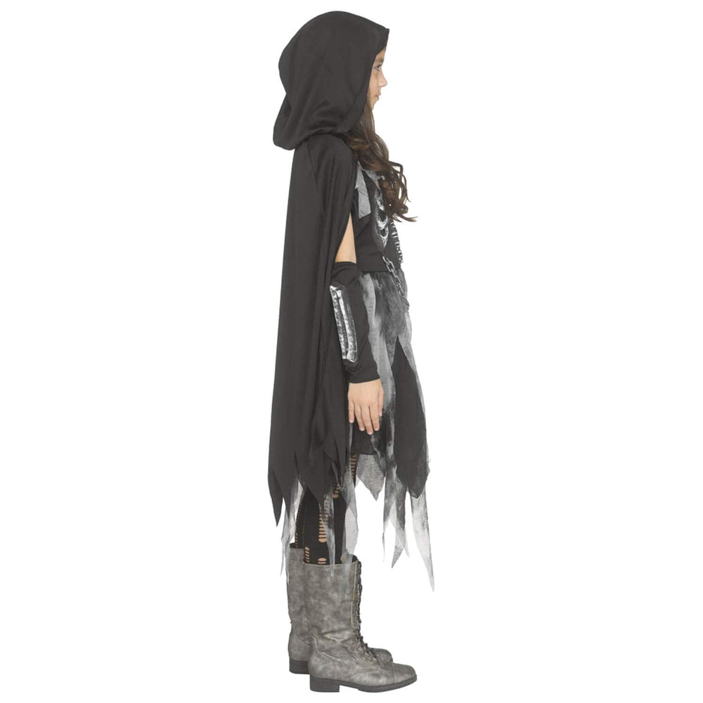 A child model shown in profile wearing a black hooded cape with tattered edges, a distressed black-and-white top, black arm warmers, and gray lace-up boots against a plain white background.