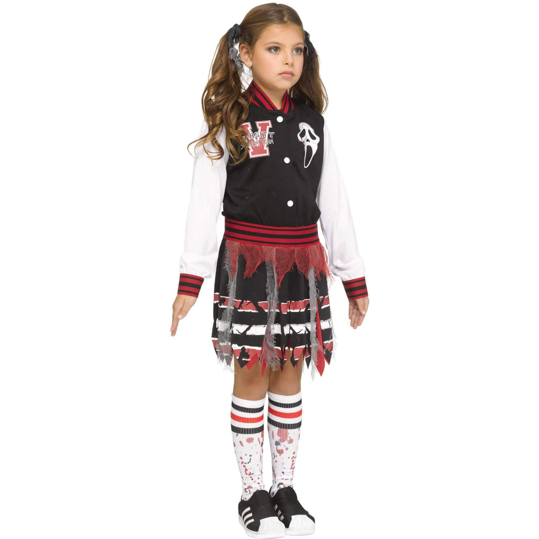 A young girl modeling a Scream varsity girl Halloween costume against a plain white background. The costume includes a black and red varsity jacket with a V and Ghost face graphic, a white long-sleeve shirt, a black and red frayed skirt, and matching blood-splattered knee socks.
